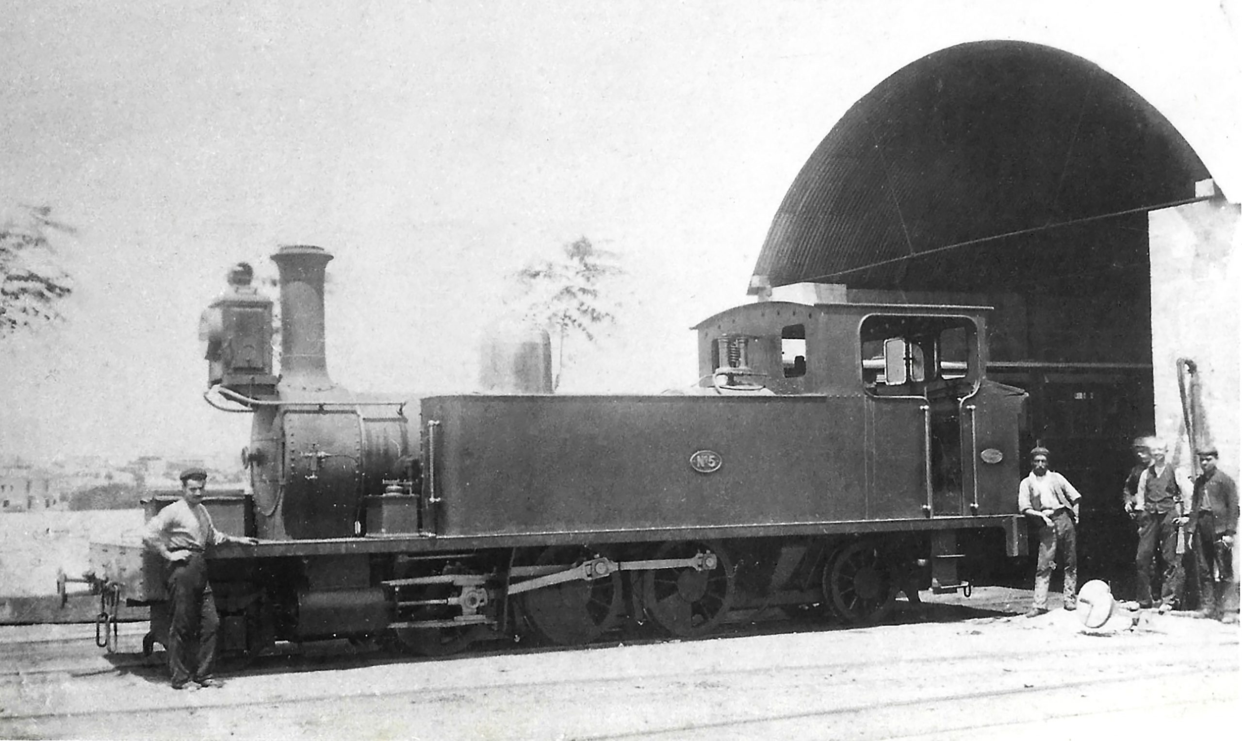 No.5 posed outside the engine shed at Hamrun in about 1895 and before its wheel configuration was changed. At this time, one road of the shed is still in use for carriages, the purpose for which it was built.