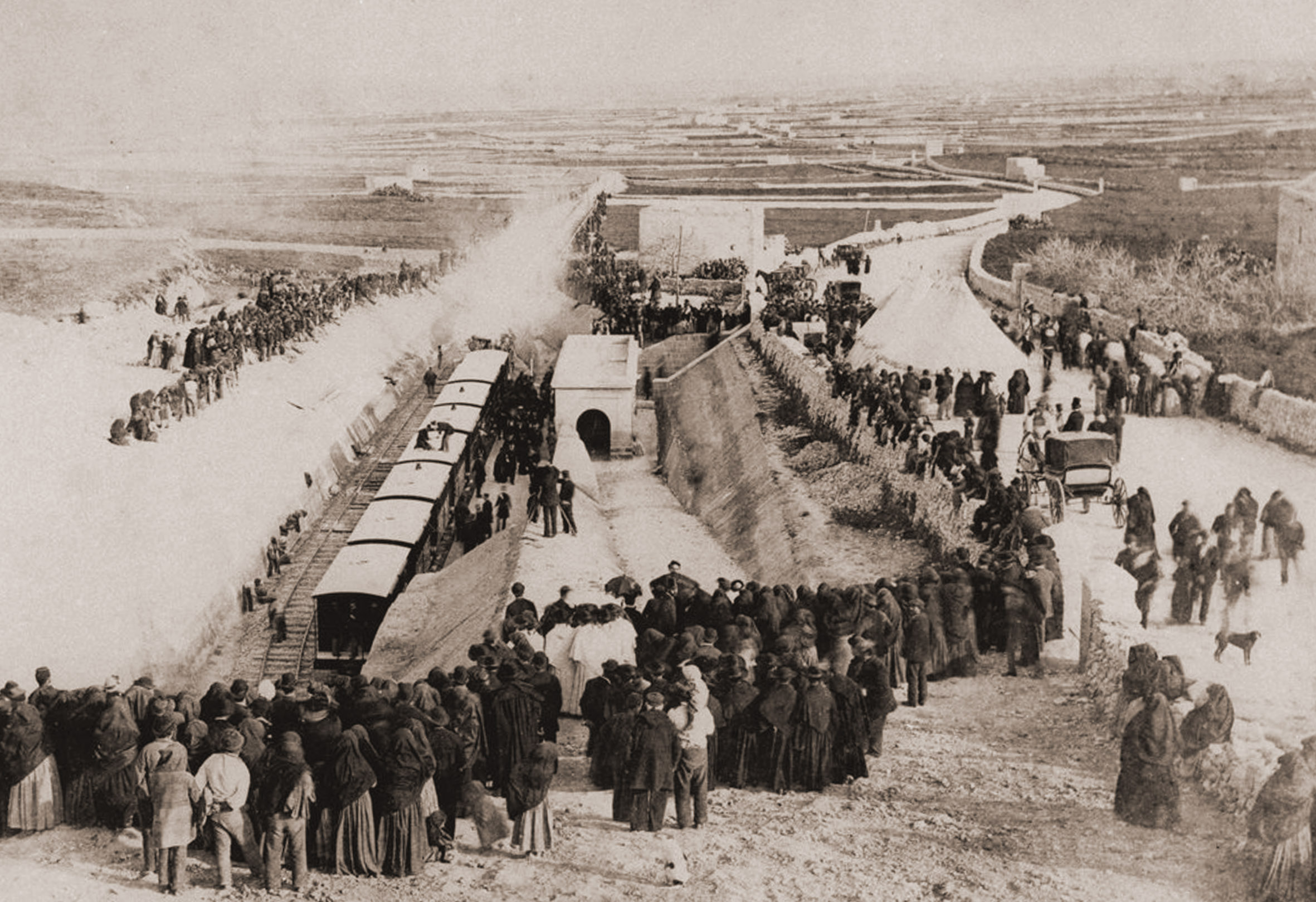 Inauguration day arrived at long last on the 28th February 1883. Crowds thronged around Notabile station to witness the arrival of the first train loaded with dignitaries, marquees on Racecource Road have being erected for their refreshment. The large bank on the left of the ramp down to the station and incomplete drainage works behind the building betray the fact that the railway was far from complete still.