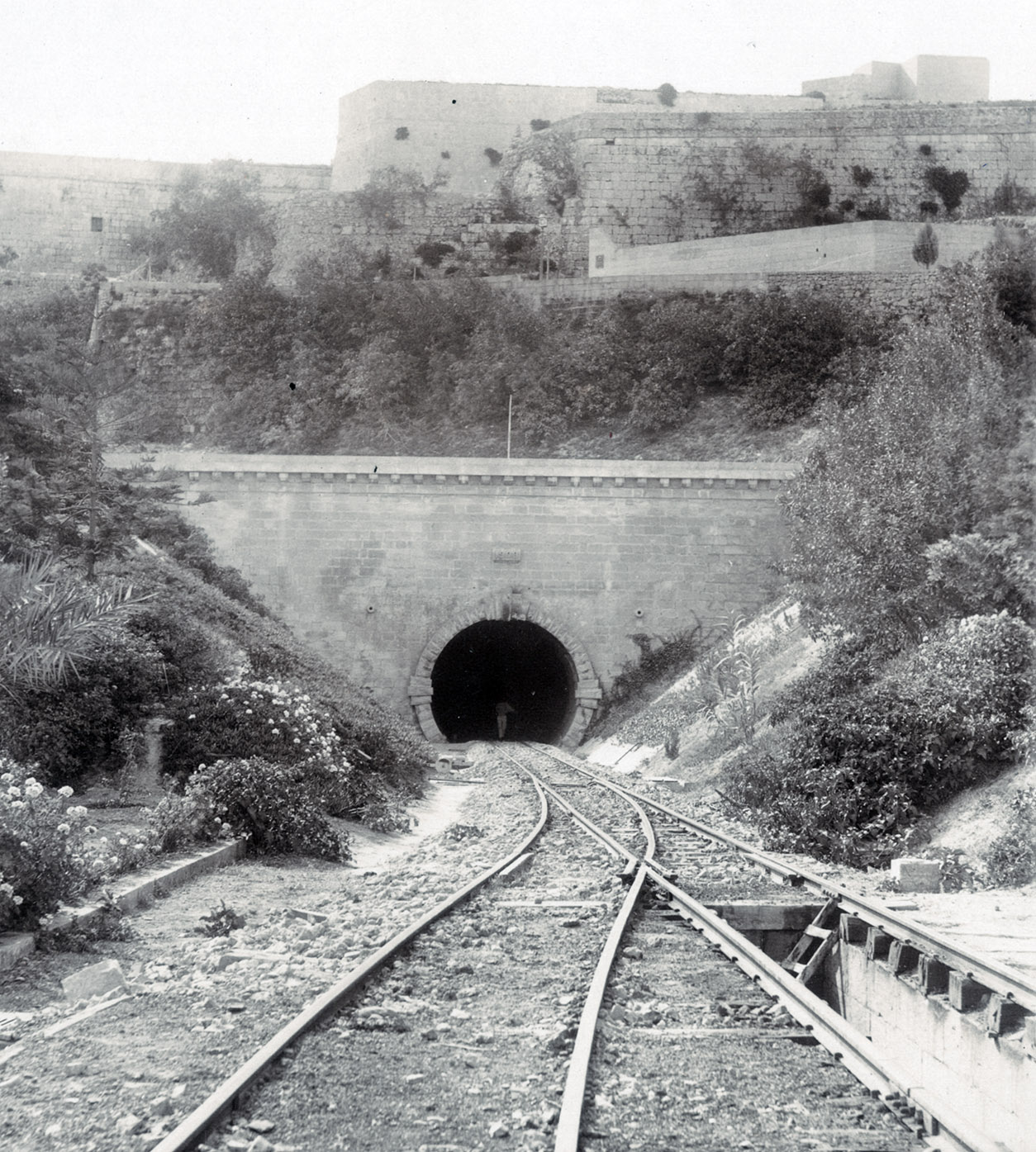 The completed tunnel portal in 1912 with the walls of Mdina towering above. Note the inspection pit between the tracks. (National Archives of Malta)