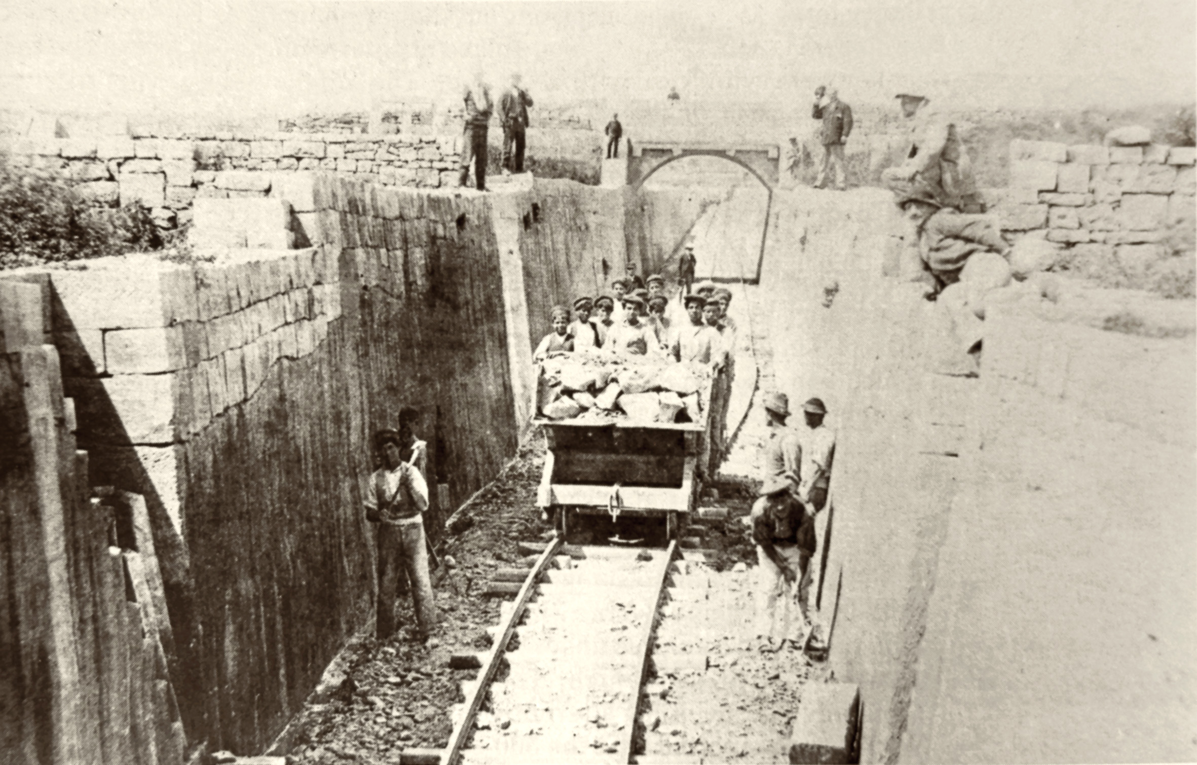 In April 1882 a series of photographs was commissioned to demonstrate progress to shareholders. This view depicts the completed cutting immediately west of Attard station site. The track shown was laid temporarily for contractor's use in transporting the excavated stone to where it would be used later in embankments.