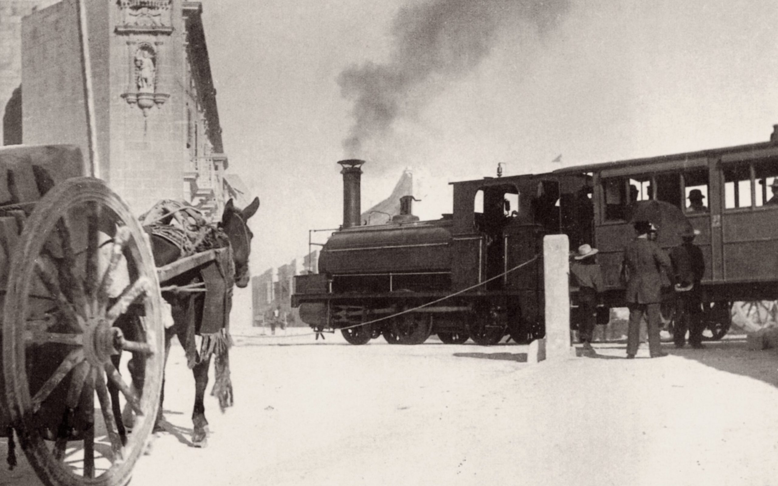 The level crossing outside Birkirkara was a perennial frustration to traffic. A plan in 1894 to dig the road under the track was cancelled by Government. Engine No.4, seen crossing here with a train for Valletta, was shortly to be transformed thanks to the new facilities and skills established at Hamrun, being outshopped in 1897.